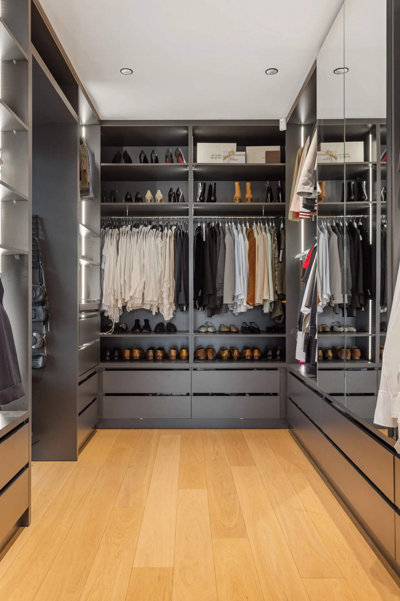 Ankleide mit beleuchteten Regalen, Schubladen und sortierter Garderobe